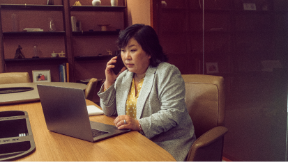 Woman talking on phone at laptop