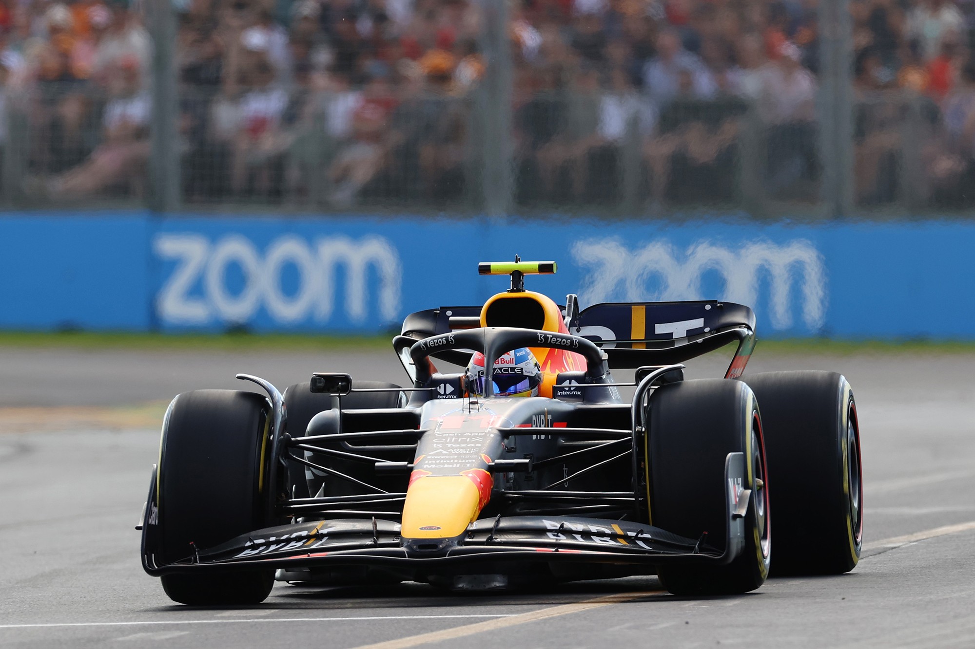 Rennwagen von Oracle Red Bull Racing auf der Rennstrecke mit Zoom Logos an der Streckenbegrenzung