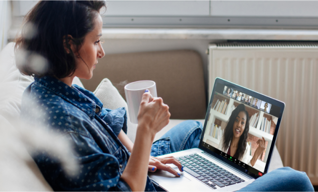 Woman on sofa with coffee using zoom meetings