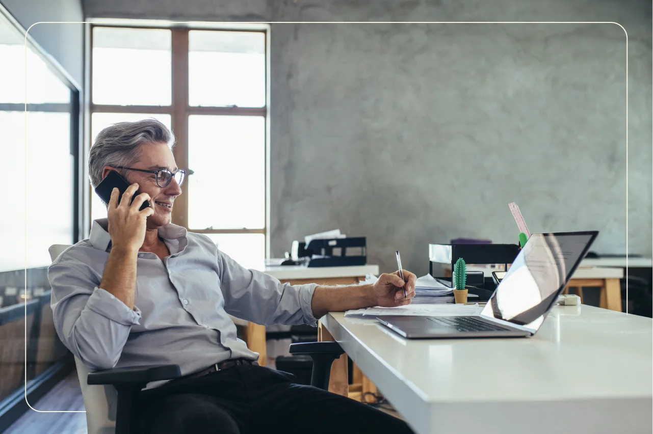 A businessman on the phone looking at his laptop