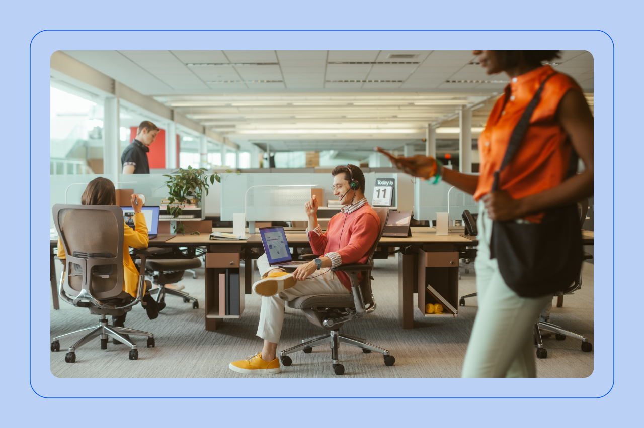 A contact center representative sits on a chair while on a call