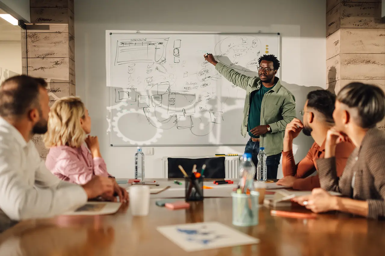  A conference room meeting with one professional presenting customer retention strategies to the rest of the team.