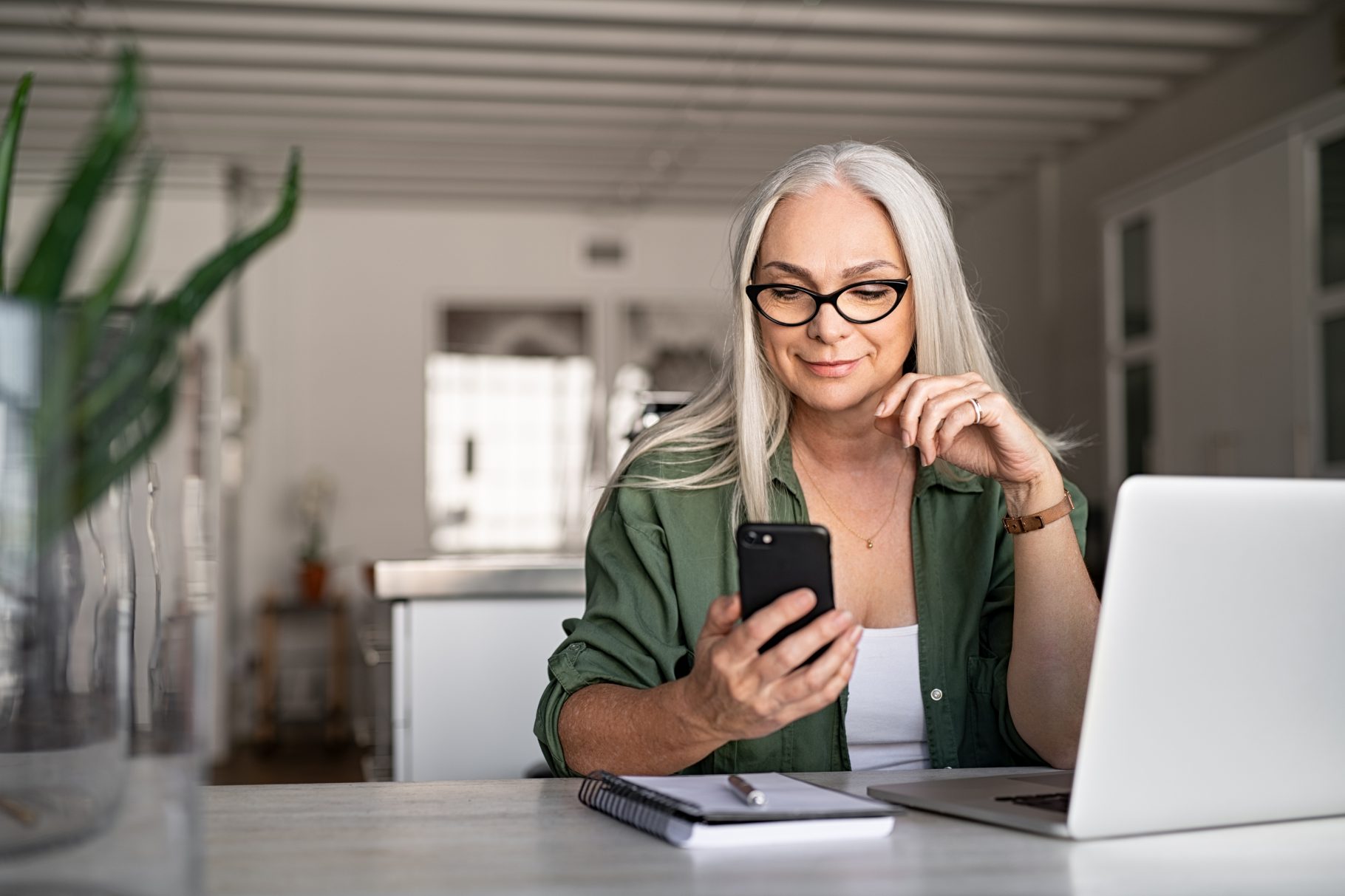 Woman on phone sitting at laptop