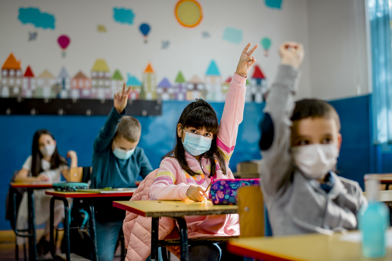 Kids raising their hand in school