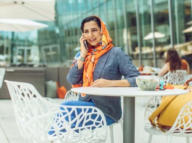 Mujer hablando por teléfono durante el almuerzo al aire libre