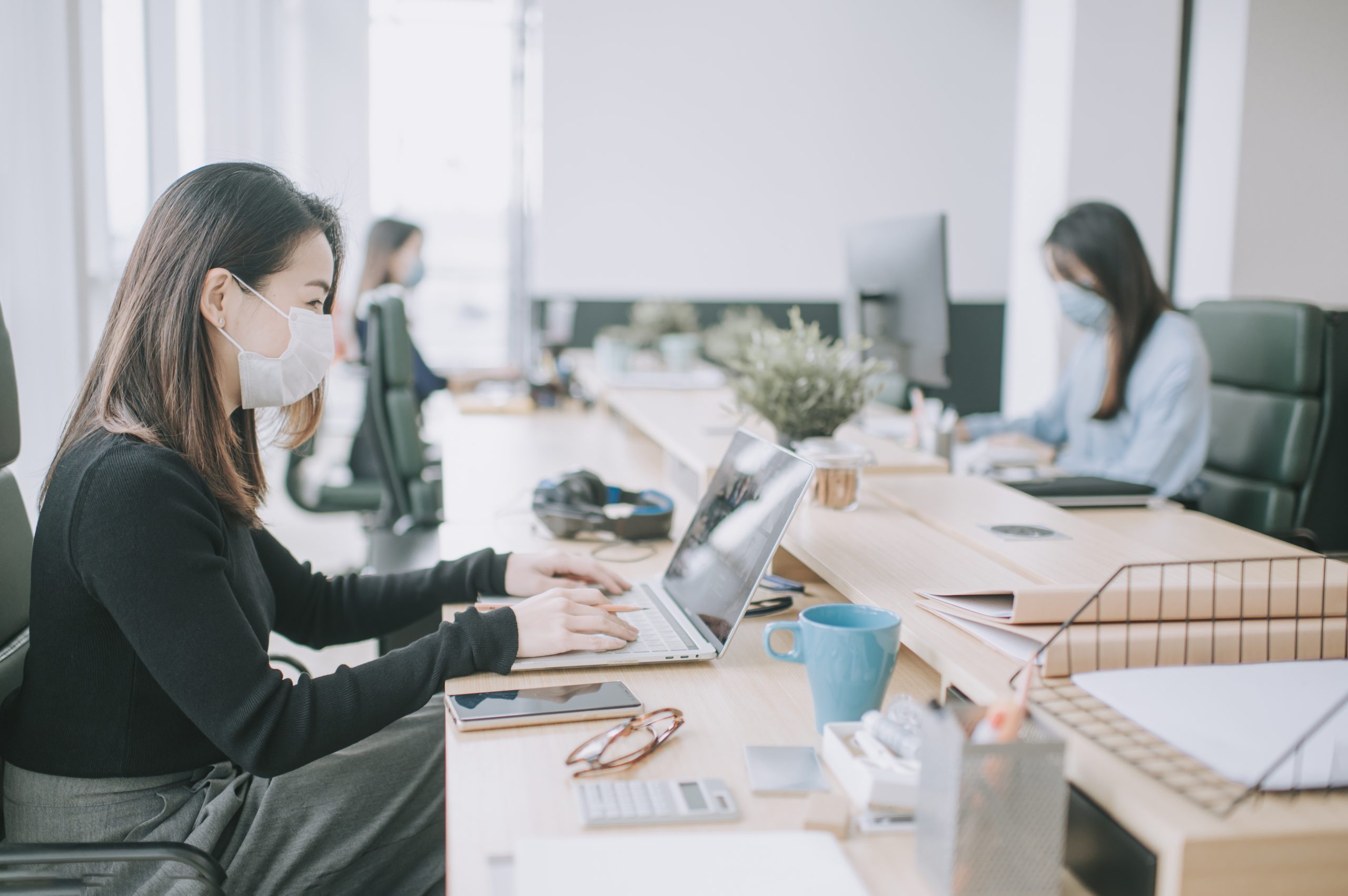 office workers wearing face mask and social distancing