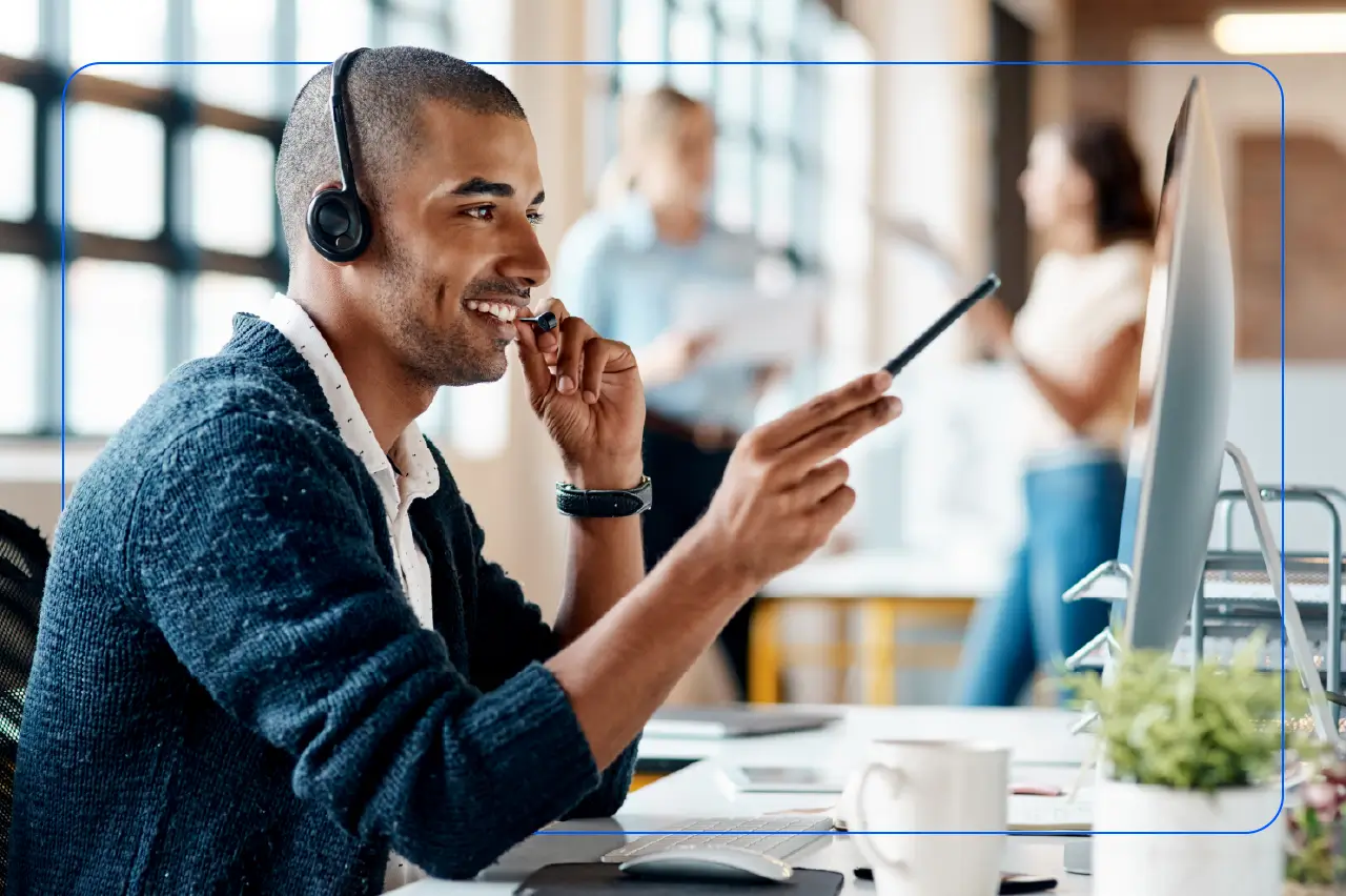 What is a softphone? Benefits + how it works Photo of a contact center agent working at a laptop with a headset on as they conduct a call.