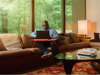 man on couch with laptop desk