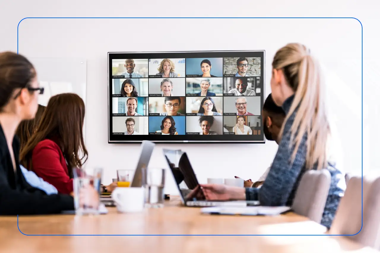 People in a meeting room looking at a screen for a video conferencing call