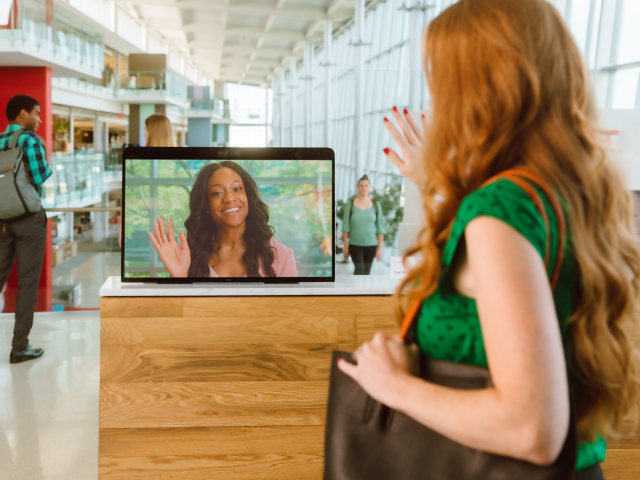 Woman waving at the computer