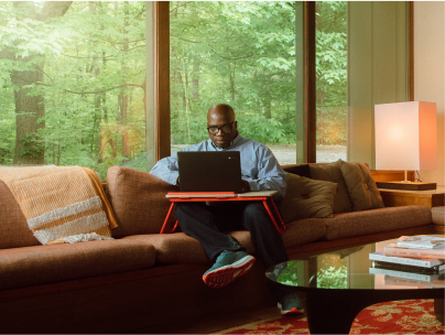 man on couch with laptop desk